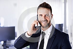 Close-up shot of a businessman having acall while standing in the office