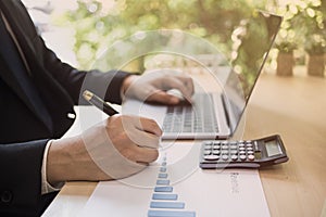 Close up shot of a businessman writing on charts paper at workstation. Modern business man writing on chart paper