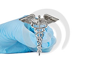 Close-up shot of a Caduceus symbol in a female hand wearing a blue nitrile glove isolated on white