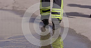 A close-up shot captures the determined stride of a firefighter as they walk towards a firetruck, showcasing their