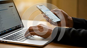 Hands Typing on Laptop and Holding Smartphone
