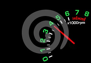 Close up shot of a car speedometer tachometer on black background.