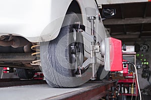 Close up shot of car wheel centering machine adjustment selective focus on machine caliper and shallow depth of field