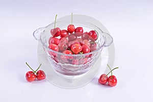 Close-up shot of cherries in a glass bowl isolated on a white background