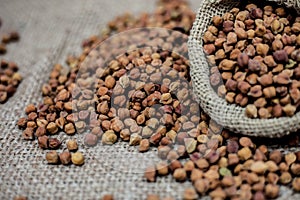 Close up shot of chickpea or chana or gram or Cicer arietinum in a gunny bag on a brown colored background.