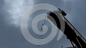 A close-up shot of a coal falling from the belt conveyor at the coal mine