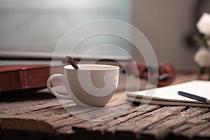 Close-up shot coffee cup and violin orchestra instrumental with vintage tone processed over wooden background select focus shallow