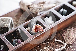 Close up shot of a collection of many different crystals on a messy wiccan witch`s altar, with blurred background