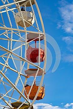A close-up shot of a colorful ferris wheel against blue sky. Holiday, vacation concept