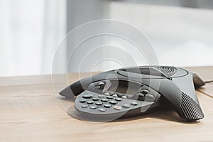 close-up shot of conference phone on wooden table