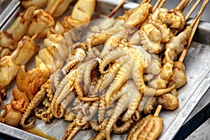 Close up shot of cooked squids pile on tray at street market of