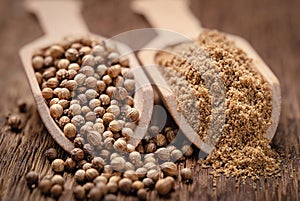 Close-up shot of coriander seeds in wood scoop whole and ground
