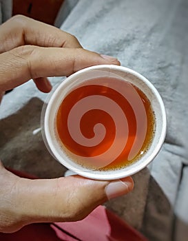 Close up shot of a cup of red tea in paper made recycled cup