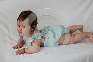 Close-up shot of a cute baby toddler on a white fabr photo