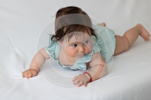 Close-up shot of a cute baby toddler on a white fabr photo