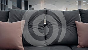 Close-up shot of a dark gray couch with red decorative pillows. 4k video