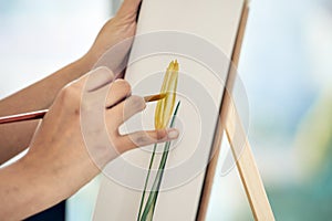 Close-up shot, delicate hand of artist meticulously paints yellow tulip flower on canvas paper, emphasizing attention to detail