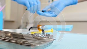 Close-up shot of dentist office and female assistant at work. Female assistant holding dental tool. Medicine, dentist