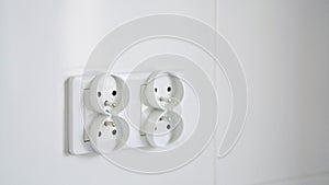 Close-up shot of a double european electrical socket isolated on a white wall. Renovation in a new apartment in the kitchen. Copy