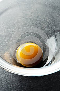 Close up shot of an egg yolk in glass bowl