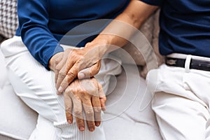 Close up shot of elderly senior couple holding hands and supporting with each other.