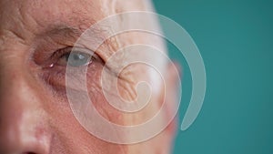 Close-up shot of eye. Old male with light blue eyes. Blinking Eye.