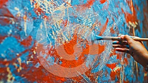 Close-up Shot of Female Artist Hand, Holding Paint Brush and Drawing Painting with Red Paint. Colo