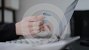 Close up shot of female hands entering credit card data, makes purchase, paying bills use e-bank application laptop sit