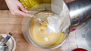 Close-up shot of female hands preparing dough for delicious cookies or biscuit muffins in the kitchen