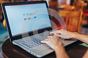 Close-up shot of female hands typing on laptop keyboard