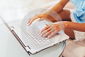 Close-up shot of female hands typing on laptop keyboard