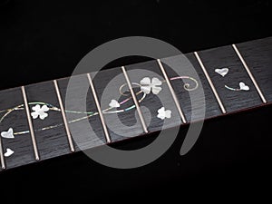 close up shot finger board pearl inlay , heart and flower , acoustic guitar