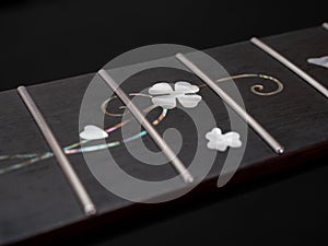 close up shot finger board pearl inlay , heart and flower , acoustic guitar, selective focus