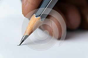 Close up shot of fingers holding a pencil and ready to write on the white paper -Start concept