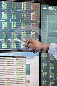 Close up shot of forex stock market trader woman pointing at screen showing real time trading data.