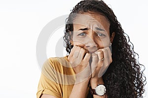 Close-up shot of freaked-out upset crying african american woman being scared and terrified trembling from fear biting