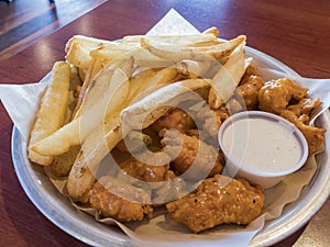 Close up shot of French fries and spicy chicken wings