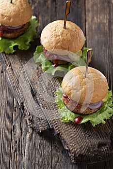 Close-up shot of fresh juicy burgers on wooden old table