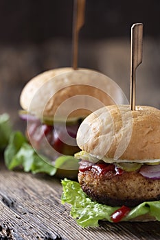 Close-up shot of fresh juicy burgers on wooden old table