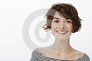 Close-up shot of friendly optimistic and happy european female coworker with stylish short haistyle, smiling joyfully