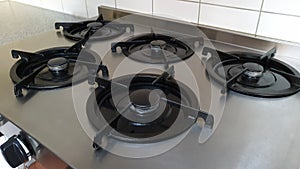 Close up shot of a gas stove with five rings in the kitchen