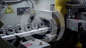 Close up shot of gears rotating in a edge banding machine.