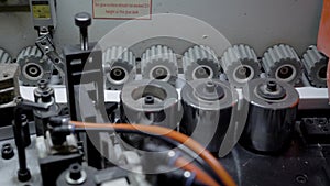 Close up shot of gears rotating in a edge banding machine.