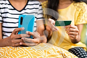 Close up shot of girls hands busy making online shopping or payment using credit card on mobile phone - concept of e