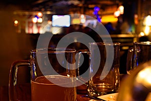 Close up shot of glass of beer on a blurry pub background. Selective focus