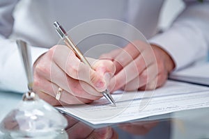 Close up shot of groom signing up the festive wedding document of marriage registration, only hands with ring, pen visible