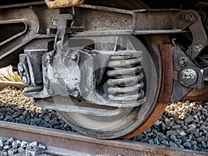 Close-up shot of a grungy old railroad car wheel on train tracks