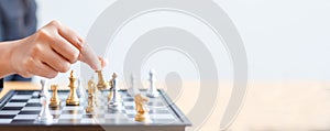 Close up shot hand of business woman moving golden chess to defeat a silver king chess on white and black chess board for