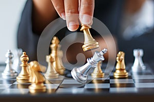Close up shot hand of business woman moving golden chess to defeat and kill silver king chess on white and black chess board for