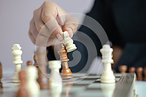 Close up shot hand of business woman playing the chess board to win by killing the king of opponent metaphor business competition